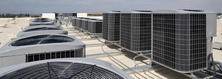 Multiple commercial rooftop HVAC condenser units installed on a large building for industrial climate control.